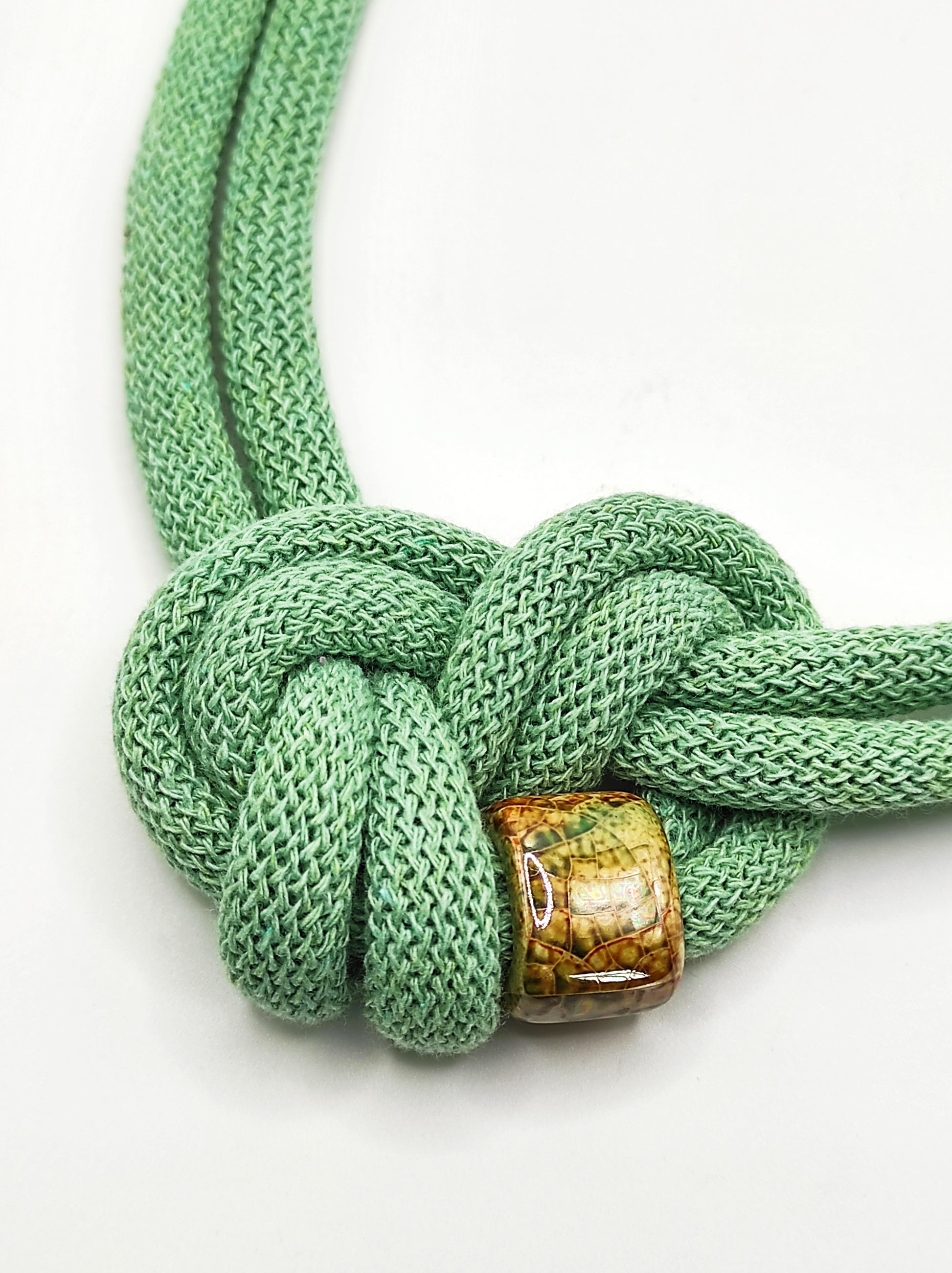 Collana di cotone con perla in ceramica smaltata, modello Circe, color aloe.
